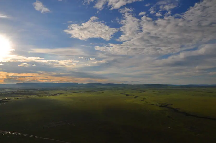 Open grassland stretching to the horizon in the Maasai Mara, the landscape the reserve's in-boundary camps sit inside